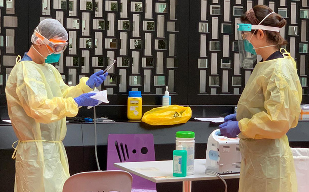  ​A staff at the Swab Isolation Facility, Concorde Hotel, wipes down a stethoscope after each patient use to prevent spread of COVID-19. By keeping our equipment clean, we are safeguarding those who may use it subsequently.