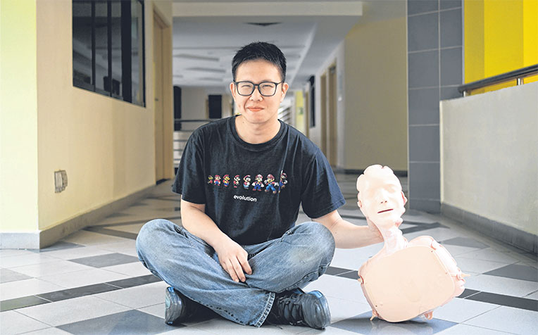with an inflatable manikin used for practising cardiopulmonary resuscitation (CPR). Knowing simplified CPR enabled Mr Lim to save the life of a cardiac arrest victim last month. He took turns with another bystander to perform CPR until an ambulance arrived.