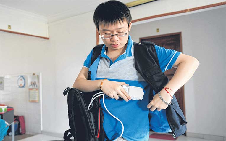  in a custom-made vest before heading to school in the morning. The vest also stores two lithium-ion batteries and cables. The whole arrangement weighs some 2kg.