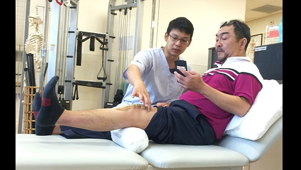  Mr Derek Lee, SGH Physiotherapist guides a knee osteoarthritis patient through an exercise with the use of the KneeBuddy Mobile App.